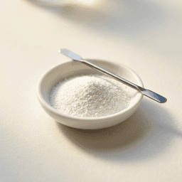 Pharmaceutical API powder in a porcelain weighing dish with micro-spatula